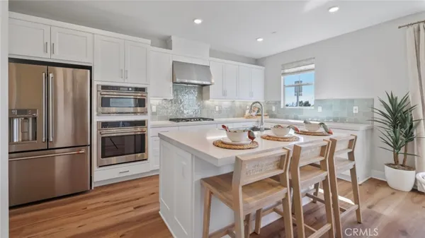 a kitchen with kitchen island a refrigerator stove microwave and cabinets