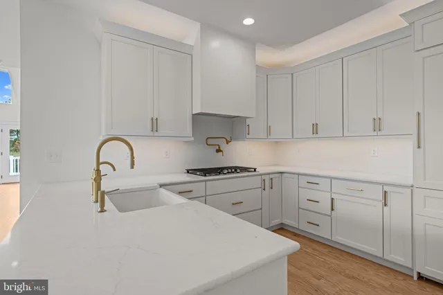 a kitchen with white cabinets a sink and appliances
