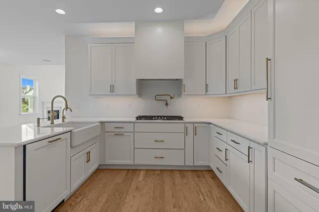 a kitchen with white cabinets appliances and sink