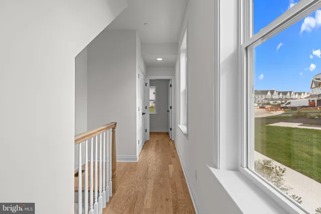 a view of a hallway with a door and wooden floor