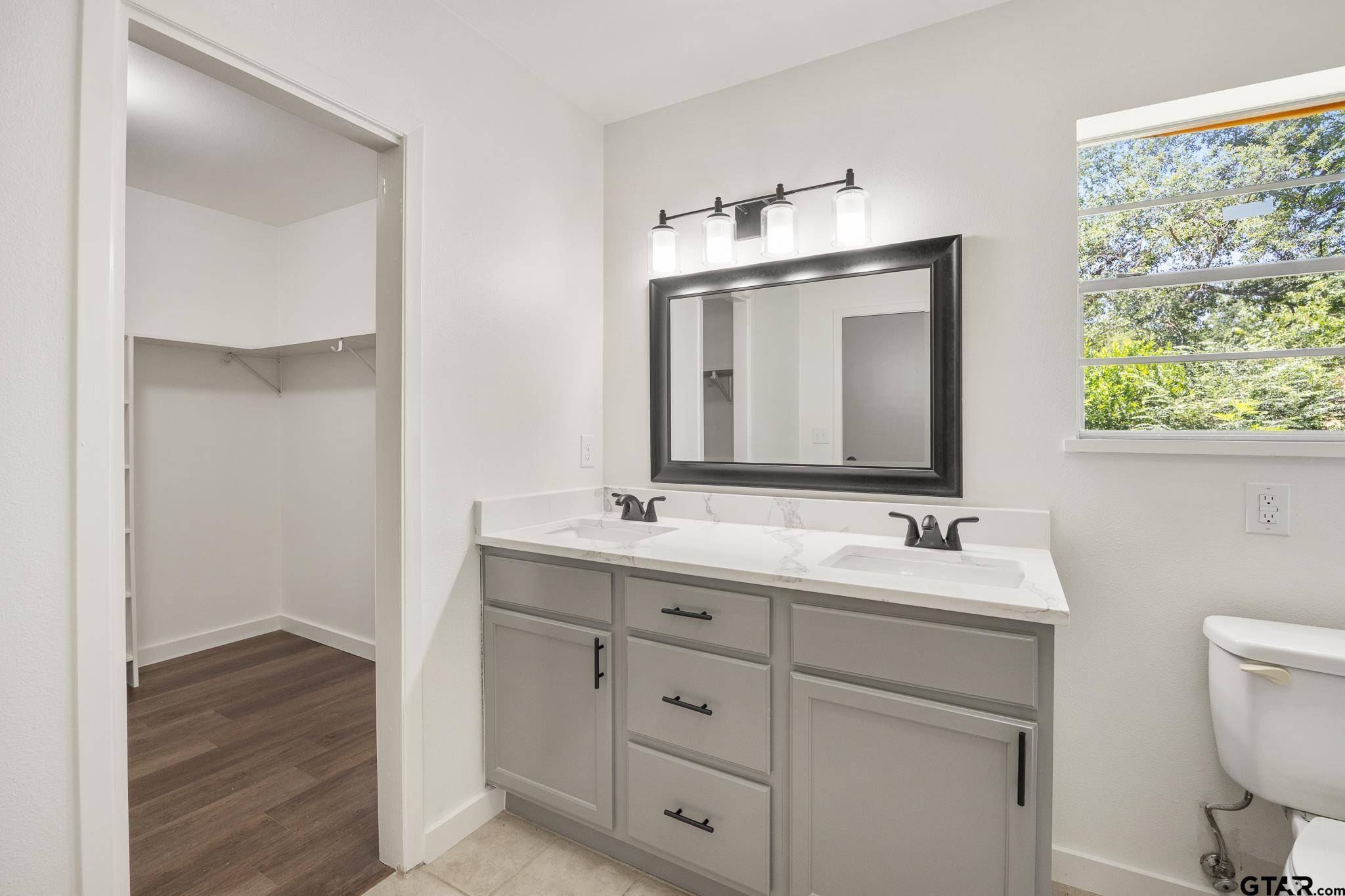 1538 North Hill Road Tyler, TX 75702 - Photo 28 of 29 a bathroom with a double vanity sink and mirror with toilet