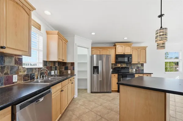 a kitchen with stainless steel appliances cabinets a sink and a large window