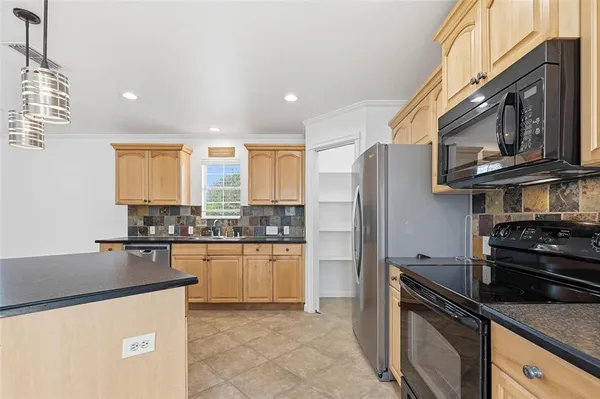 a kitchen with granite countertop stainless steel appliances and wooden cabinets
