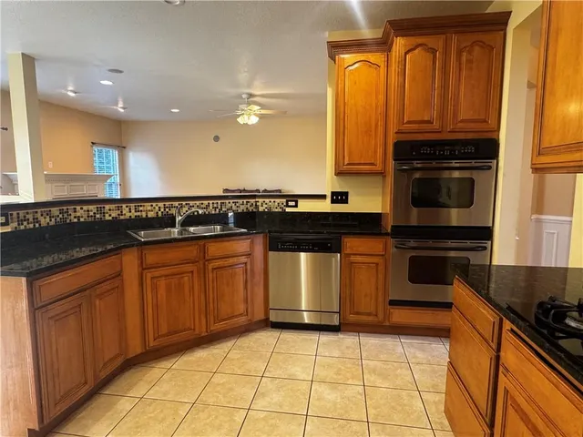 a kitchen with stainless steel appliances granite countertop a refrigerator and a stove