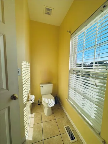 a view of an empty room and window and chandelier fan
