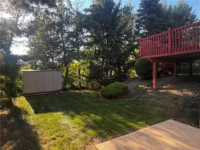 a view of a house with a yard fire pit and tree s