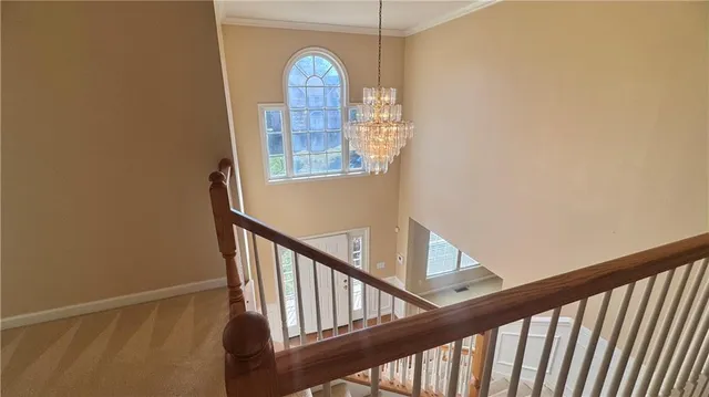 a view of a hallway with wooden floor and stairs