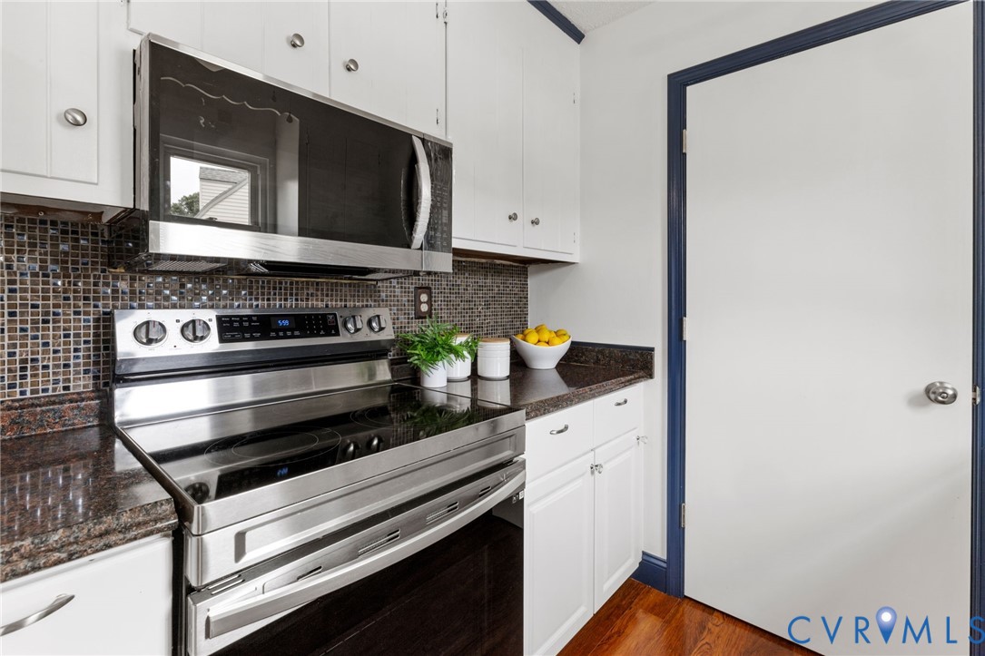 15908 Tri Gate Road Chester, VA 23831 - Photo 11 of 28 a kitchen with stainless steel appliances a stove microwave and cabinets