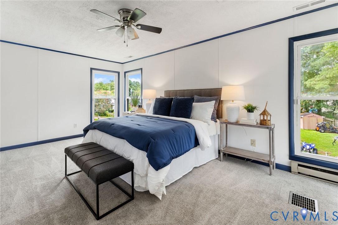 15908 Tri Gate Road Chester, VA 23831 - Photo 15 of 28 a bedroom with a bed and a chandelier