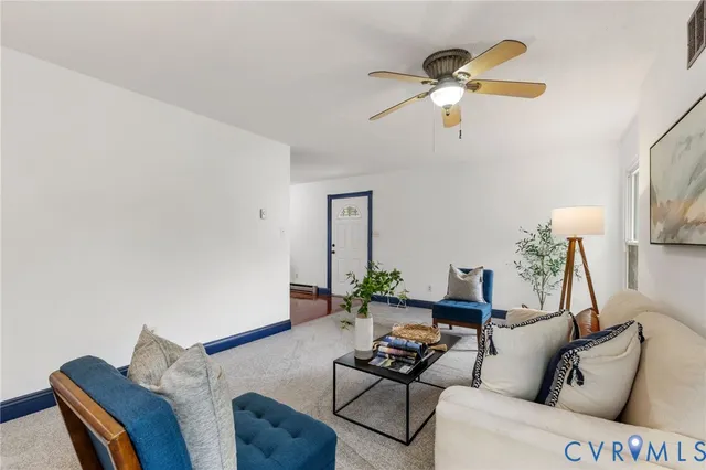 a living room with furniture and a ceiling fan