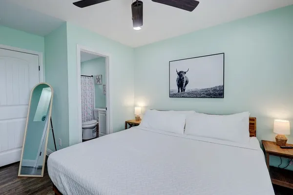 a bedroom with a bed and a painting on the wall