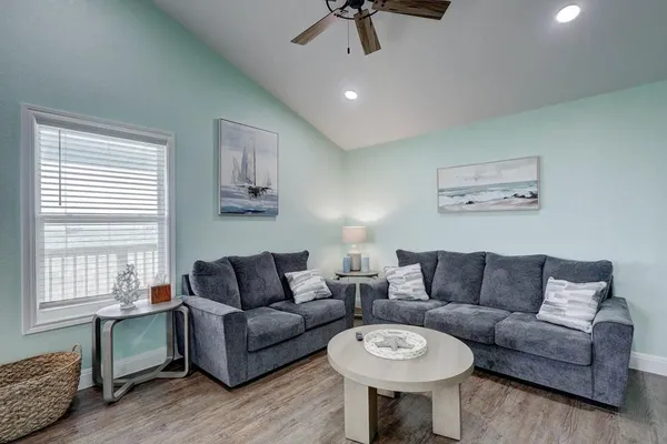 a living room with furniture a ceiling fan and a window