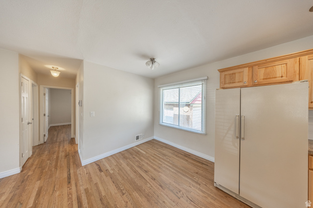 193 Locust Street Clearfield, UT 84015 - Photo 11 of 29 Kitchen area featuring wood-finish flooring, light-toned walls, a window with blinds, natural wood cabinetry, and a side-by-side refrigerator