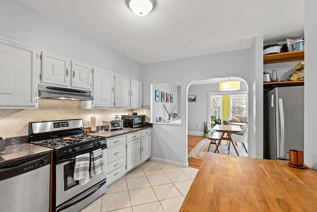 a kitchen with stainless steel appliances granite countertop a stove top oven a sink dishwasher and cabinets with wooden floor