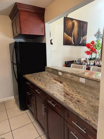 a living room with stainless steel appliances kitchen island granite countertop a refrigerator and a stove