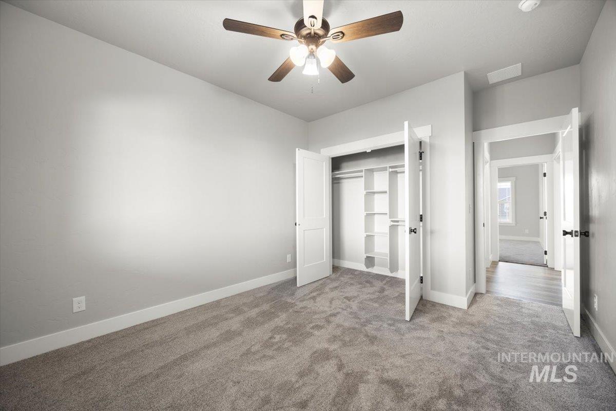 103 Ash Street Parma, ID 83660 - Photo 9 of 22 Unfurnished bedroom with carpet, a closet, and a ceiling fan