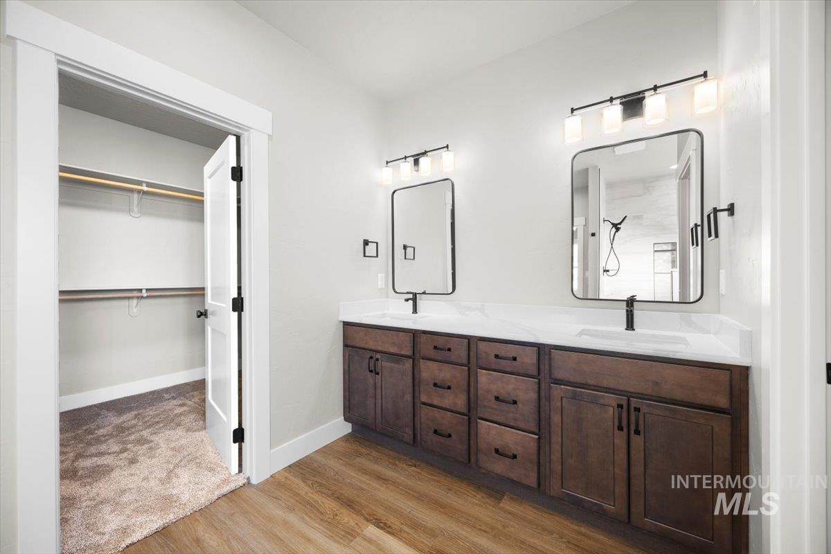 103 Ash Street Parma, ID 83660 - Photo 14 of 22 Full bathroom with double vanity, light wood finished floors, and a spacious closet