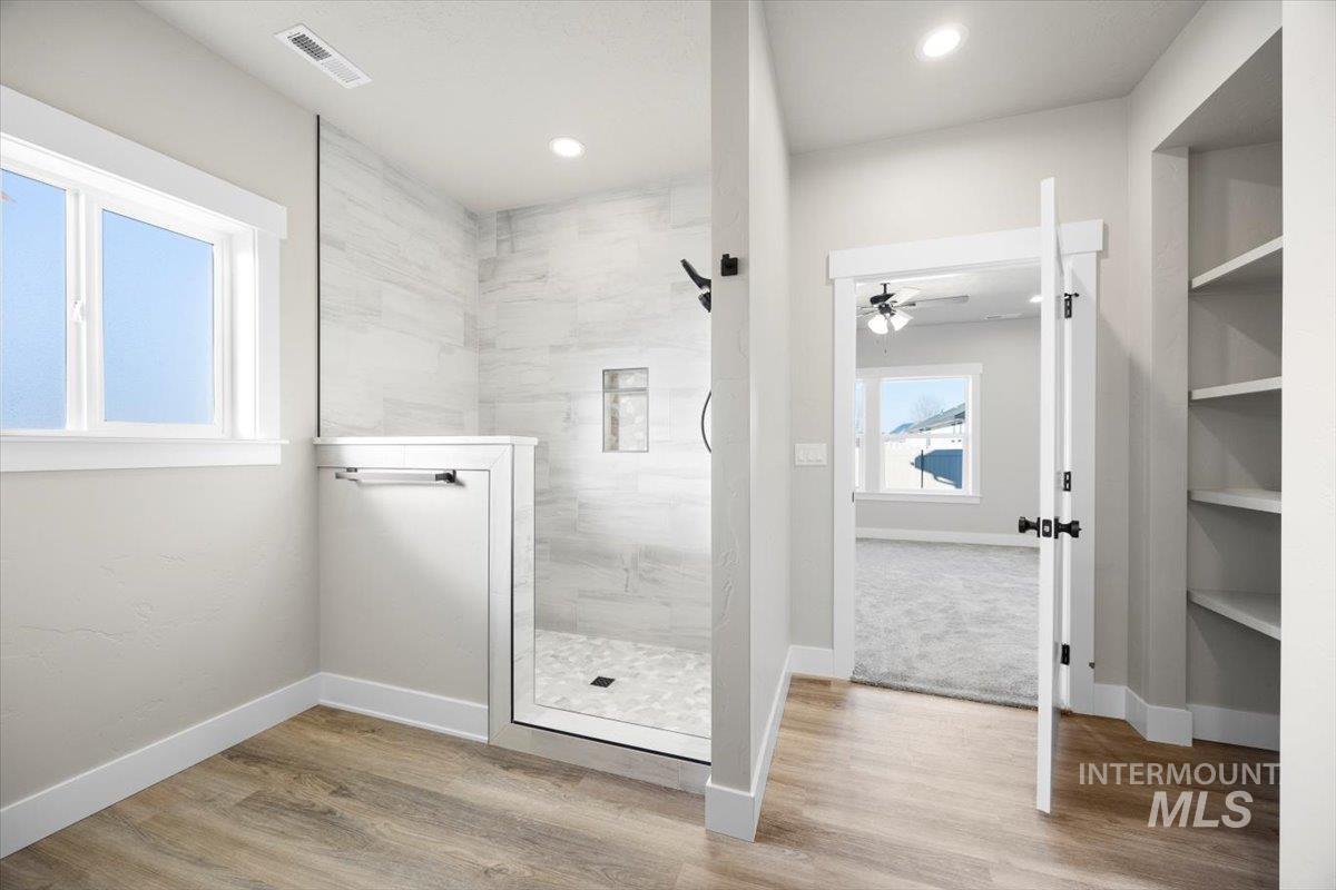 103 Ash Street Parma, ID 83660 - Photo 16 of 22 Full bath with walk in shower, light wood-style floors, and ceiling fan