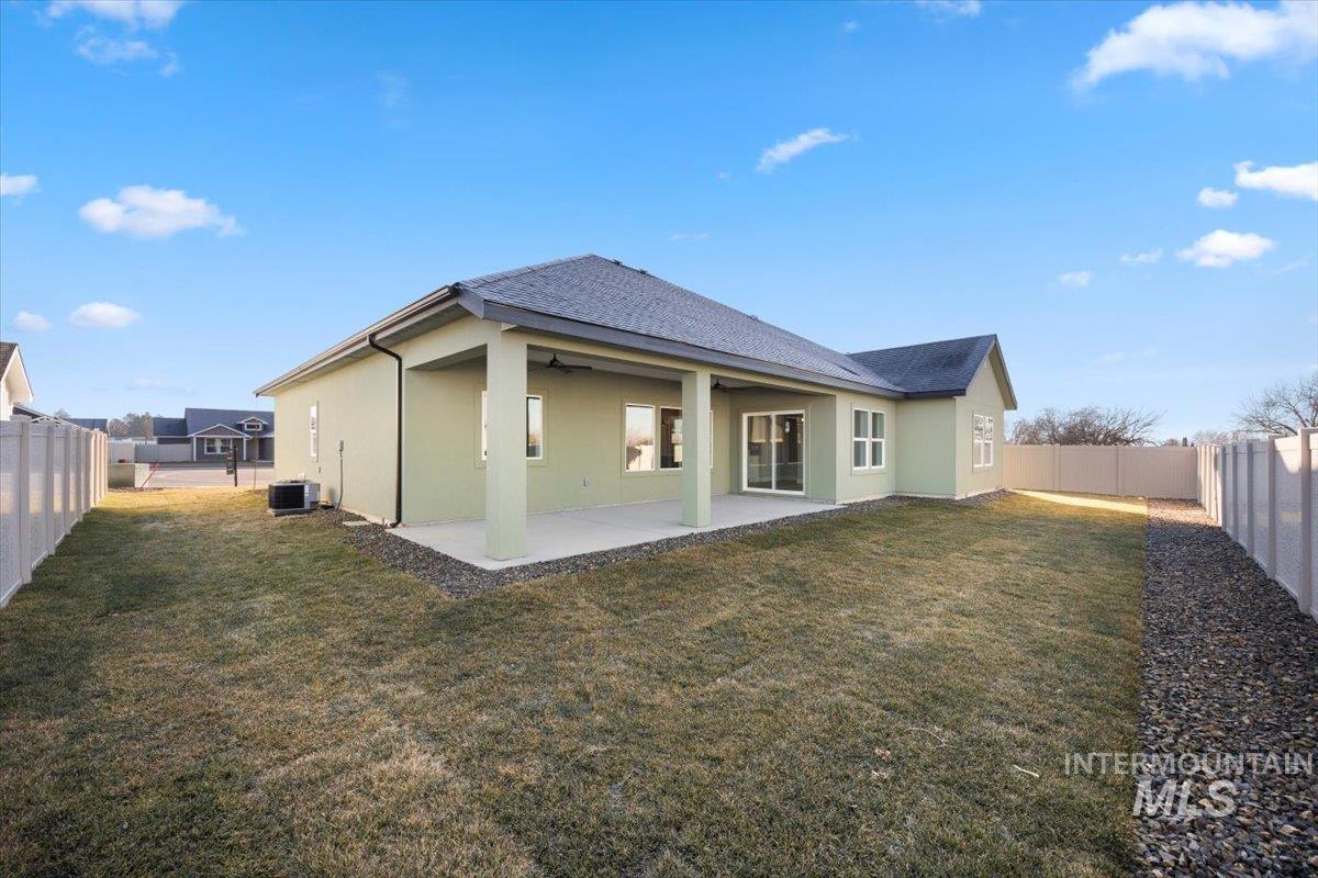 103 Ash Street Parma, ID 83660 - Photo 17 of 22 Rear view of house featuring a fenced backyard, stucco siding, a patio, and roof with shingles