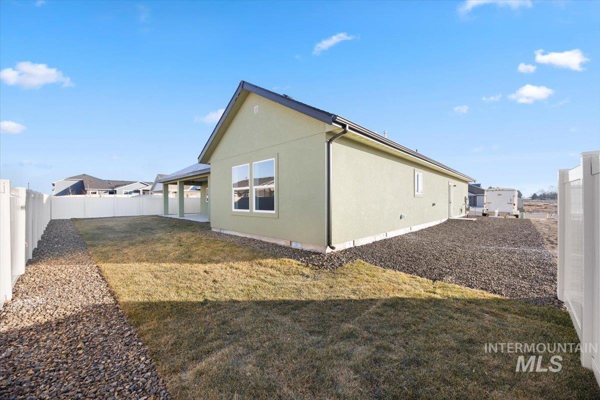 103 Ash Street Parma, ID 83660 - Photo 18 of 22 View of side of home featuring a fenced backyard and a patio