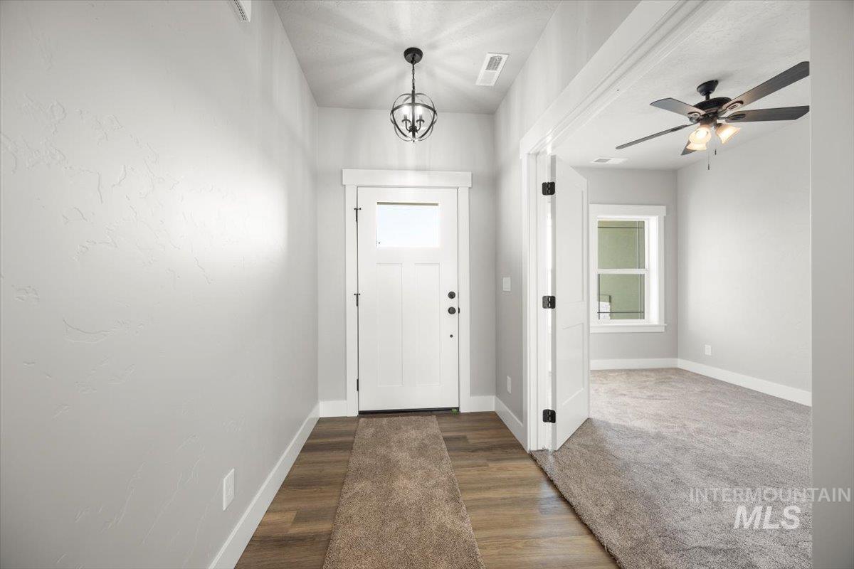 103 Ash Street Parma, ID 83660 - Photo 5 of 22 Entryway with ceiling fan, dark wood-style floors, and hanging lights