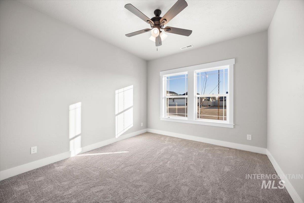 103 Ash Street Parma, ID 83660 - Photo 7 of 22 Empty room featuring carpet flooring and a ceiling fan