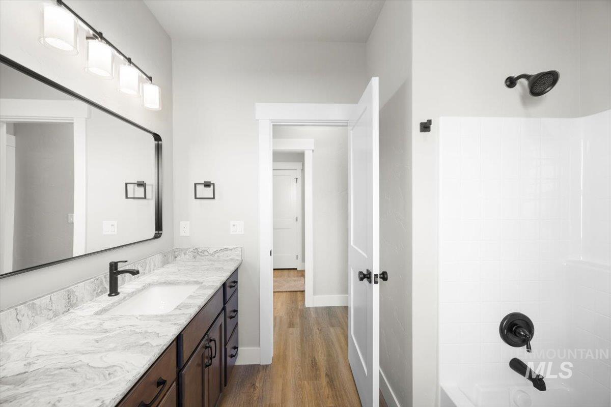 103 Ash Street Parma, ID 83660 - Photo 8 of 22 Bathroom with vanity, dark wood-type flooring, and bathtub / shower combination
