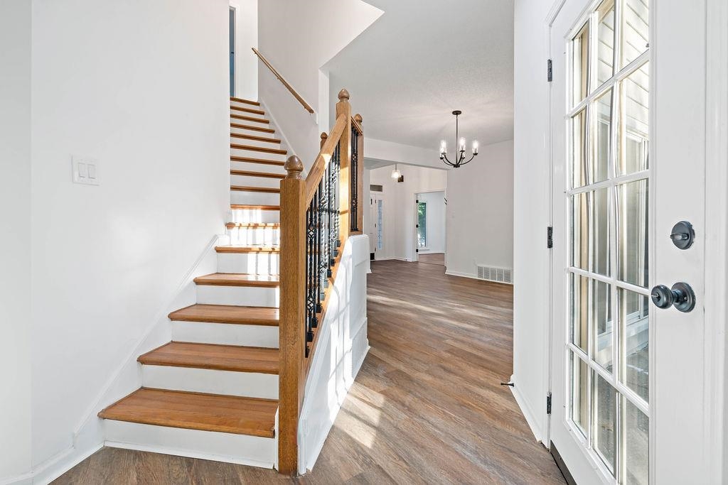 2389 Carrol Ridge Lane Cordova, TN 38016 - Photo 9 of 18 Staircase featuring wood finished floors and a chandelier