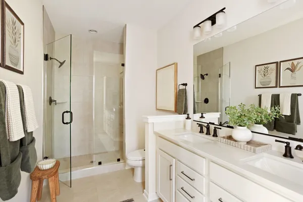 a bathroom with a double vanity sink toilet and shower