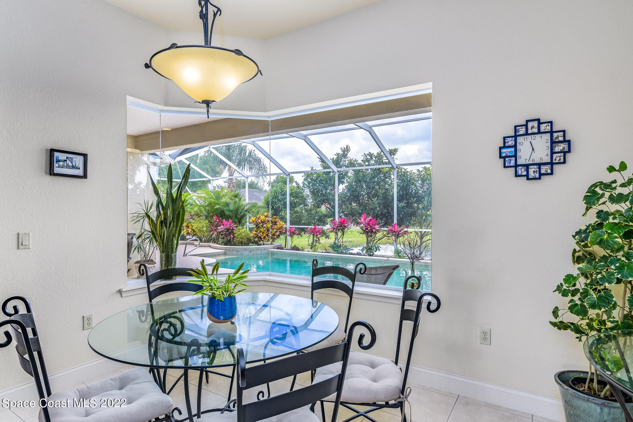 4251 Stoney Point Road Melbourne, FL 32940 - Photo 12 of 62 a dining room with furniture potted plants and a chandelier