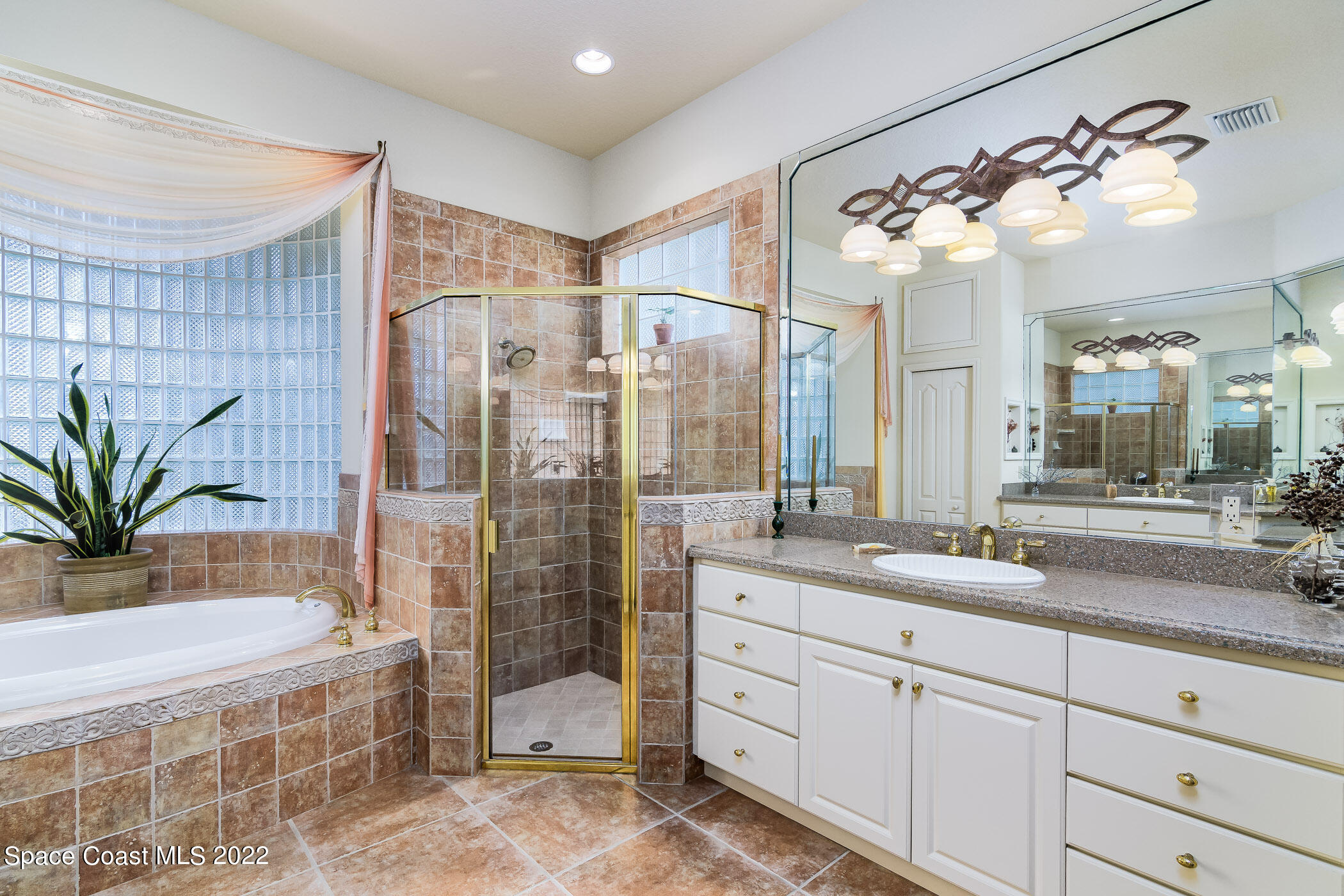 4251 Stoney Point Road Melbourne, FL 32940 - Photo 22 of 62 a bathroom with a granite countertop sink a mirror a glass door a shower and vanity