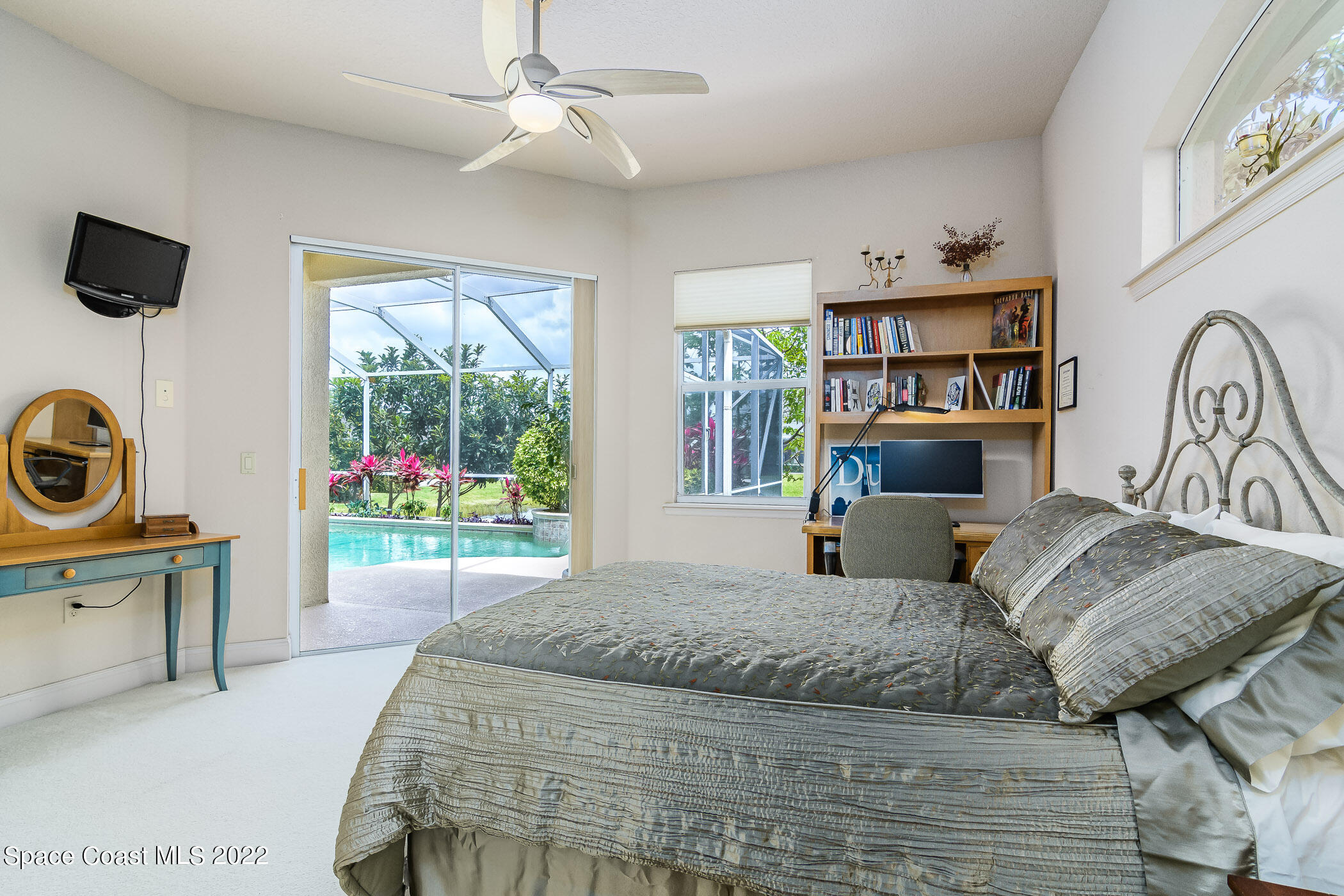 4251 Stoney Point Road Melbourne, FL 32940 - Photo 24 of 62 a bedroom with a bed a dresser and flat screen tv