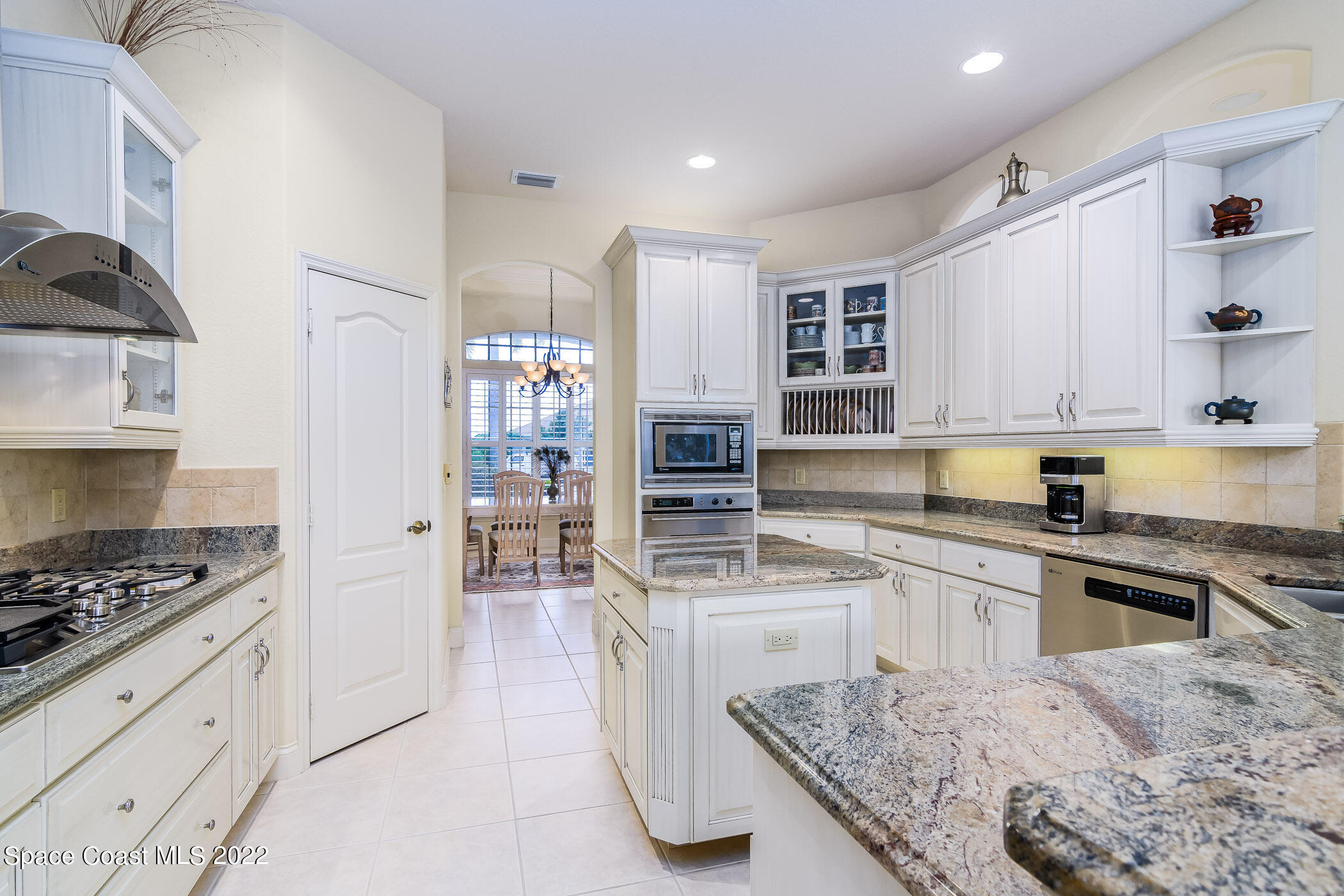 4251 Stoney Point Road Melbourne, FL 32940 - Photo 7 of 62 a kitchen with stainless steel appliances kitchen island granite countertop a stove and a sink