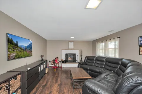 a living room with furniture a flat screen tv and a floor to ceiling window