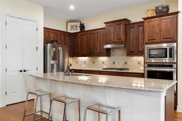 a kitchen with stainless steel appliances granite countertop a refrigerator and a stove top oven