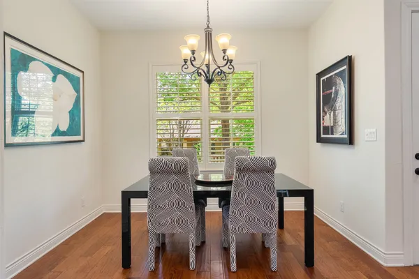a view of a dining room with furniture a chandelier and wooden floor