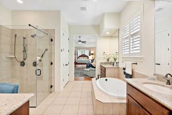 a en suite bathroom with a granite countertop sink mirror and shower