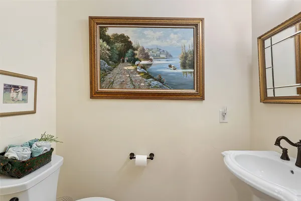 a bathroom with a painting on the wall and a sink