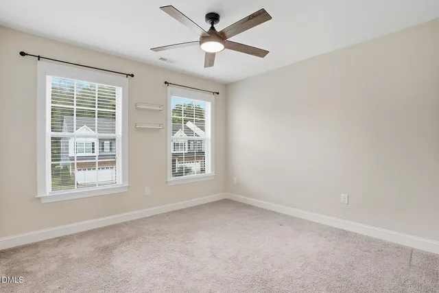 an empty room with a window and a fan