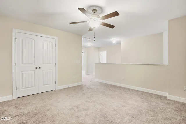 an empty room with a ceiling fan and a window
