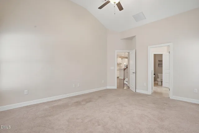 an empty room with fan and windows
