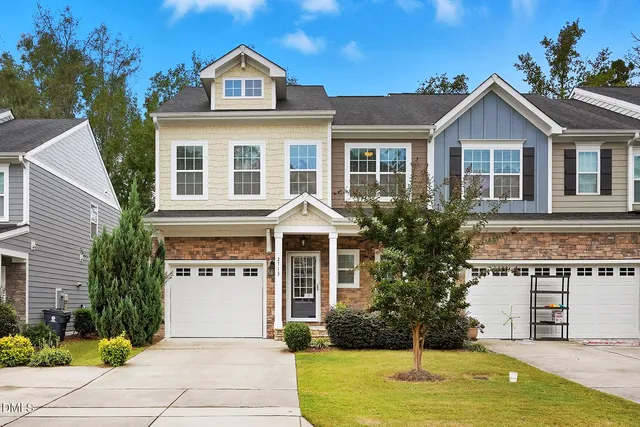 a front view of a house with yard and green space