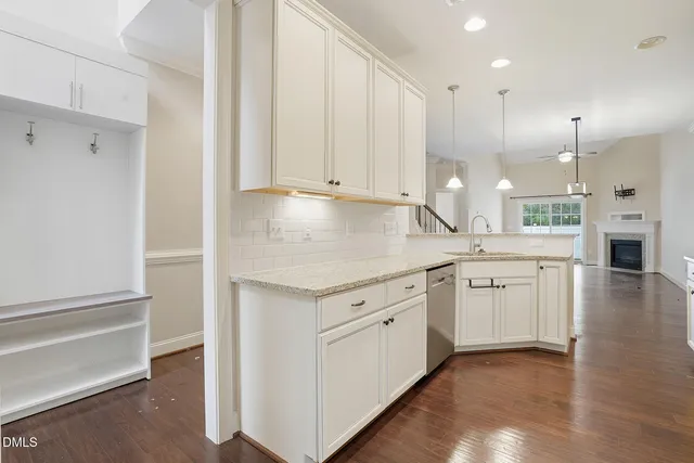 a kitchen with white cabinets and sink