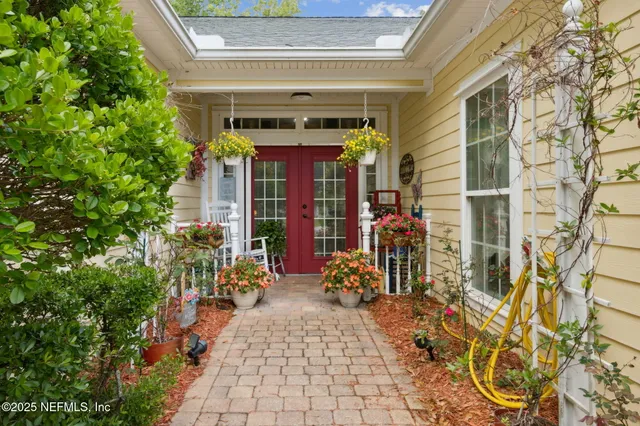 a view of a porch with chairs and potted plants