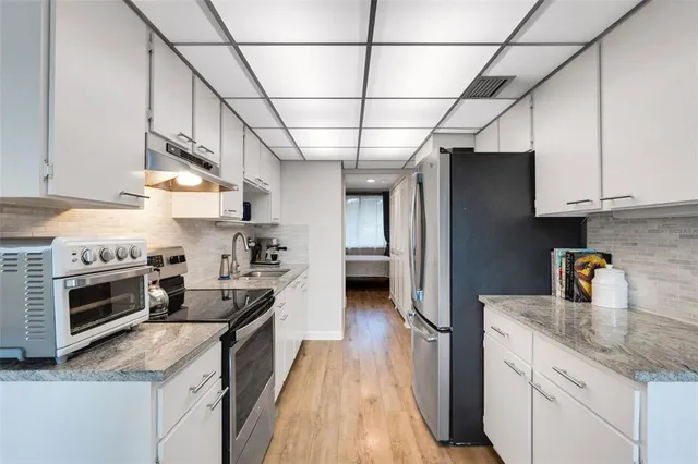 a kitchen with stainless steel appliances granite countertop a stove and a sink