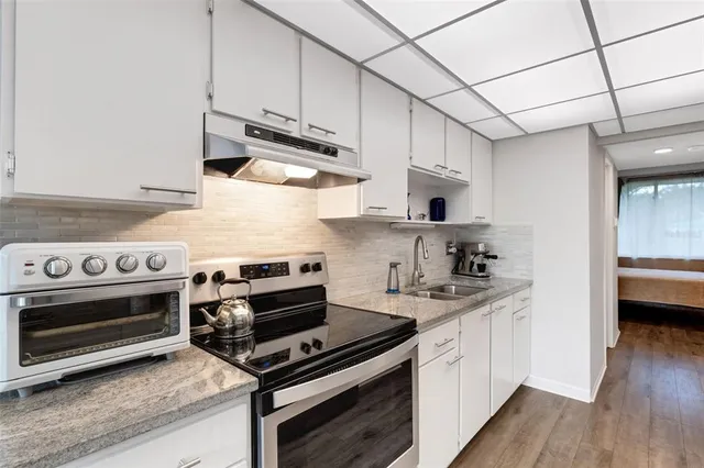 a kitchen with stainless steel appliances granite countertop a refrigerator and a sink