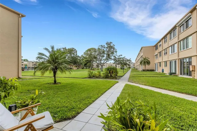a view of a house with potted plants and a bench