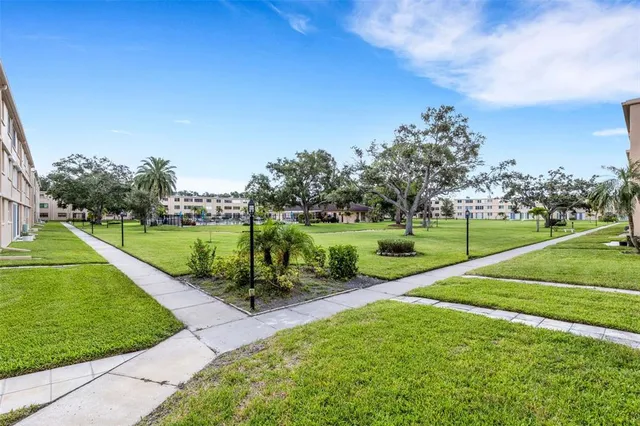 a view of a big house with a big yard and palm trees