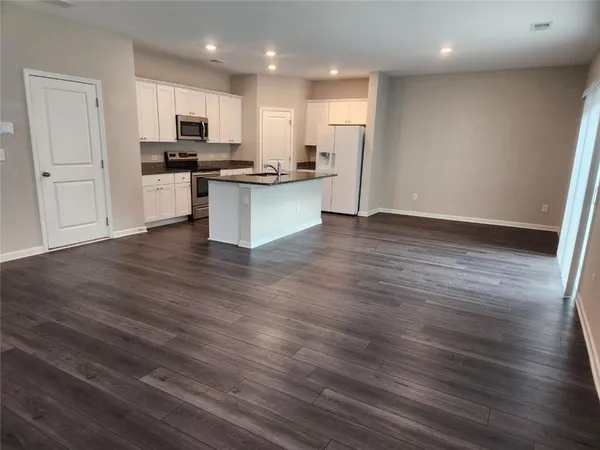 a view of kitchen with wooden floor and electronic appliances