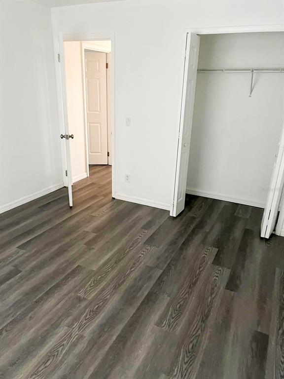 9817 Turf Way, Unit GE Orlando, FL 32837 - Photo 18 of 19 an empty room with wooden floor and white wall